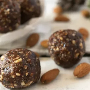 Photo of superfood energy balls with almonds on white tabletop