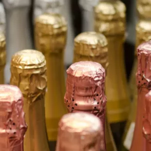 Bottles of champagne with silver, gold, and rose gold foil