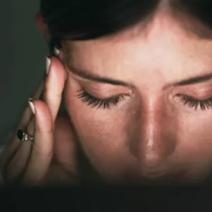 Stressed woman rubbing temples