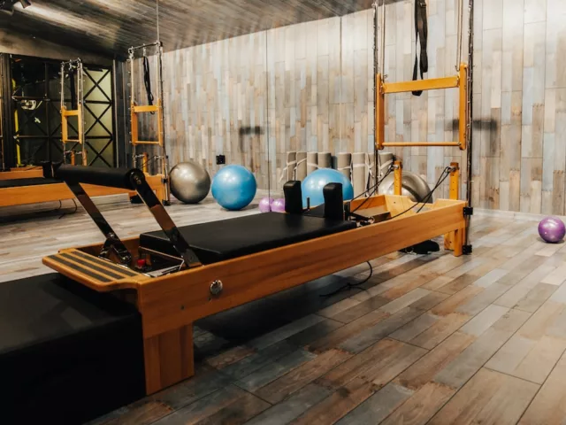 Pilates reformer machine with athletic balls in wooden Pilates studio