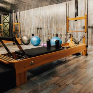 Pilates reformer machine with athletic balls in wooden Pilates studio