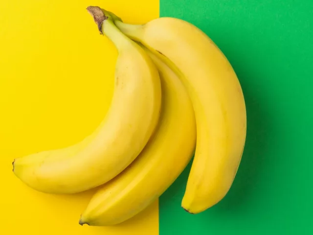 Bunch of bananas on half yellow half green background