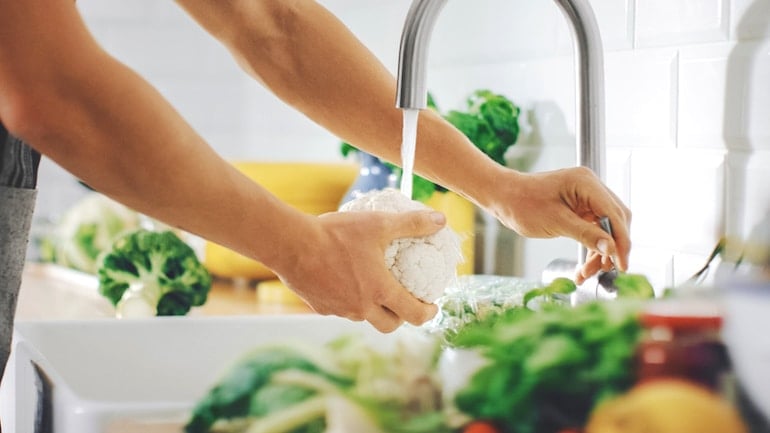 Woman rinsing cauliflower to make rice