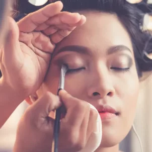 Makeup artist doing a woman's makeup for a ceremony during wedding season