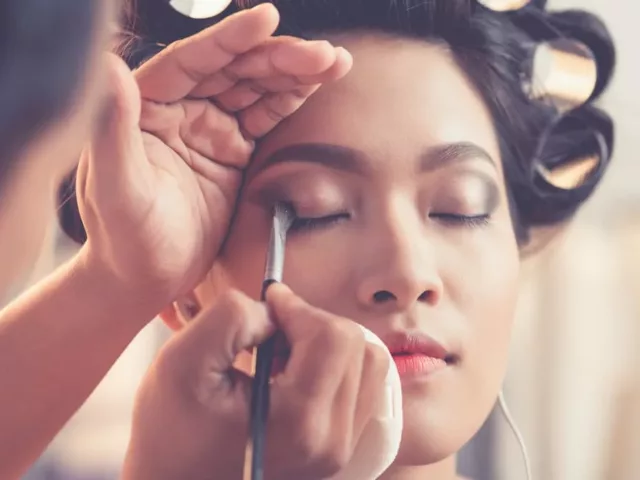 Makeup artist doing a woman's makeup for a ceremony during wedding season