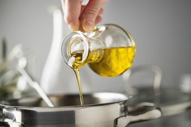 Pouring olive oil into a cooking pan