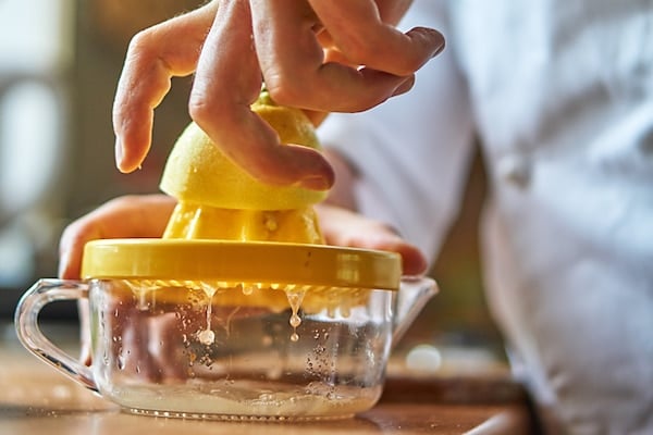 Person juicing a lemon to follow the extreme Master Cleanse diet