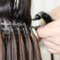 Woman getting hair extensions put in at a salon