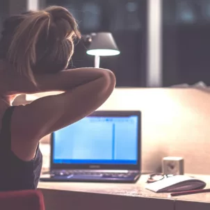 Woman stretching her neck while working late at the office
