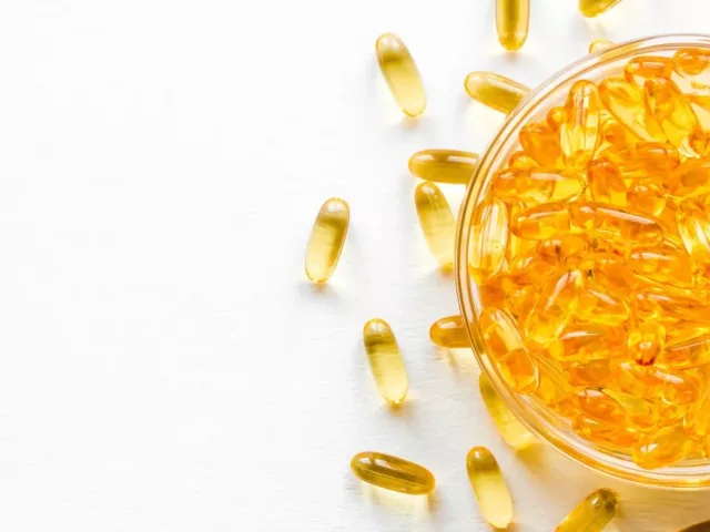 Bowl of omega fatty acid capsules on white table