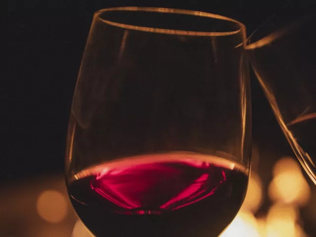 Two glasses of wine in front of darkness and fireplace
