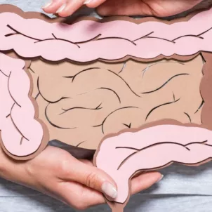 Woman holding paper cutout of intestinal tract