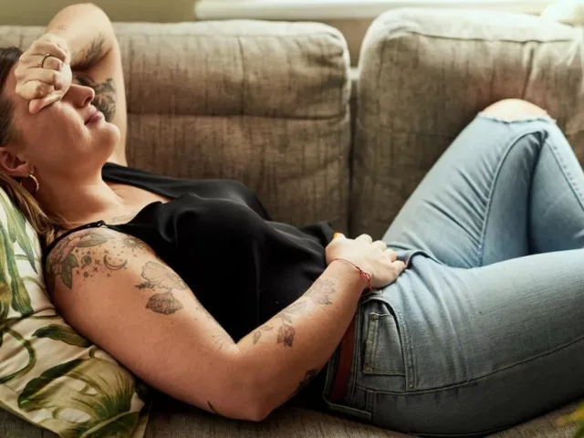 Woman lying on couch fatigue from candida overgrowth