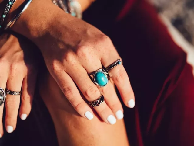 Woman wearing rings and white non-toxic nail polish