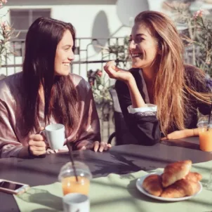 Parisian woman smiling at lunch because they know the secret to glowing skin