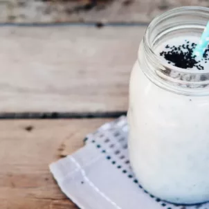 Jar of Skin-Hydrating Coconut Crush Smoothie on wooden table outdoors