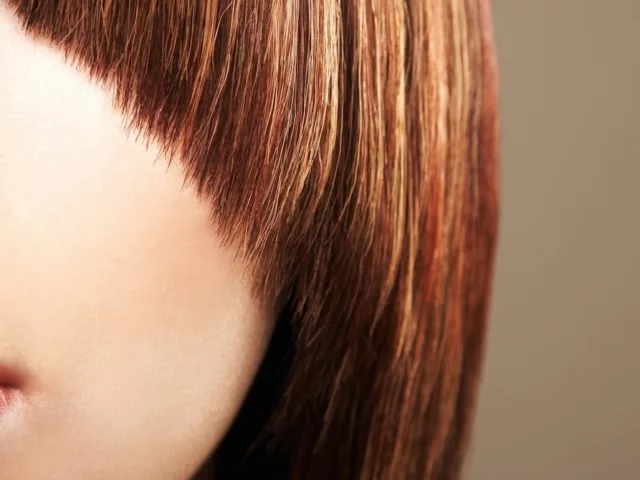 Close up crop of a woman with a bad haircut and bangs.