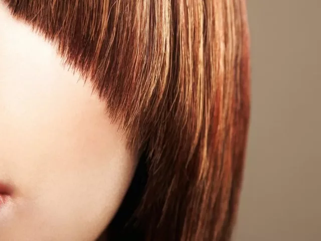 Close up crop of a woman with a bad haircut and bangs.