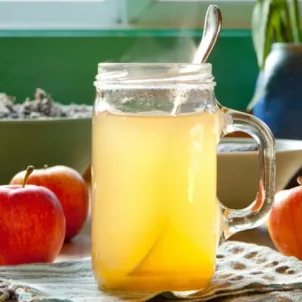 Apple Cider Vinegar in a jar next to red apples