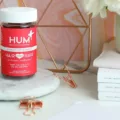 HUM Hair Sweet Hair gummies on marble pedestal on cute desk