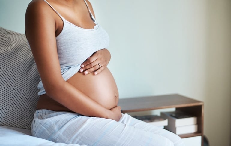 Pregnant woman with hands on her belly for a pregnant digestion concept