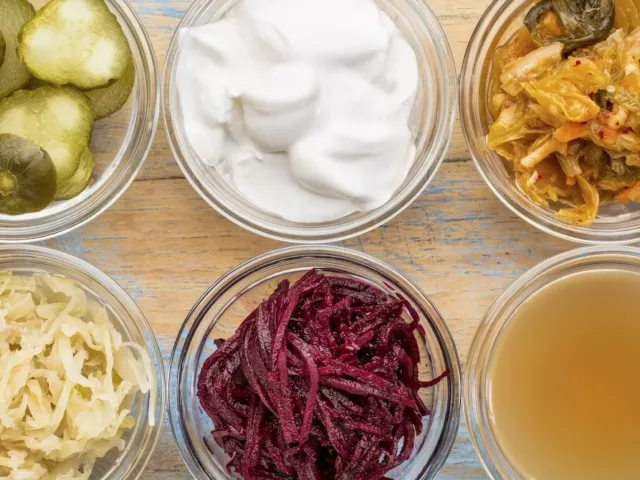 Ultimate Probiotic Foods, including pickles, kimchi, and sauerkraut in clear glass ramekins