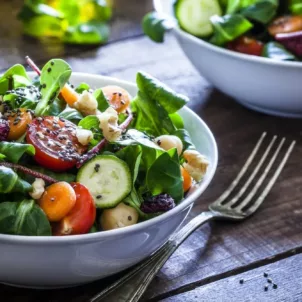 Healthy salad with sesame seeds and dried berries on wooden table