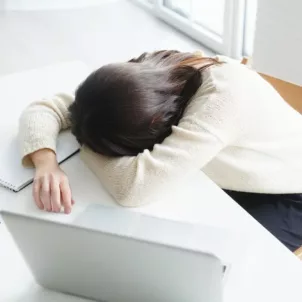 Woman passed out at her desk due to fatigue and work stress