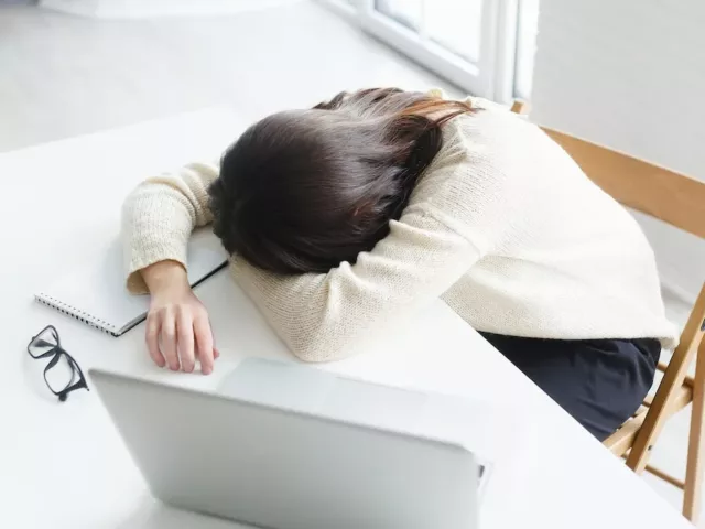 Woman passed out at her desk due to fatigue and work stress