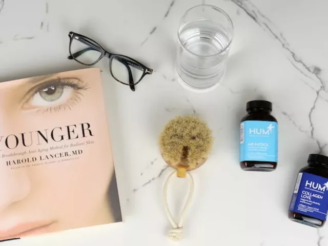 Younger book by Dr. Lancer next to glasses and bottles of HUM Nutrition supplements for skin and anti-aging