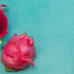 Cut open dragonfruit on aqua background