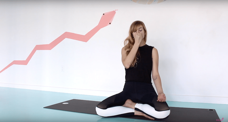 Yoga teacher demonstrating alternate nostril breathing exercise