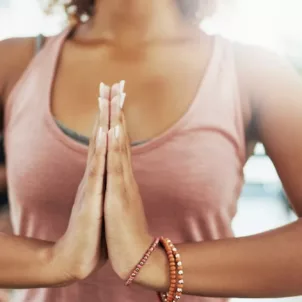 Woman with hands to heart in an Ayurvedic class