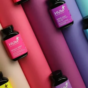 HUM Nutrition supplement bottles on rainbow background