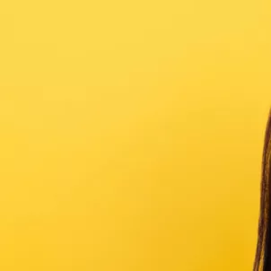 Woman with beautiful skin and eyes closed in front of yellow backdrop