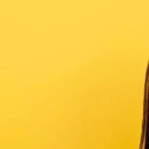 Woman with beautiful skin and eyes closed in front of yellow backdrop