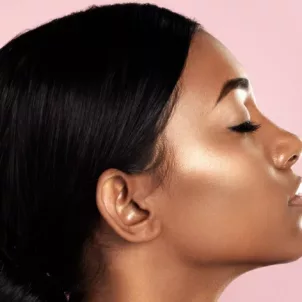 Profile of woman with glowing skin on pink background