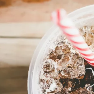 Diet soda made with aspartame in a glass with ice