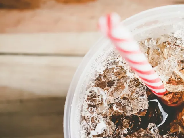 Diet soda made with aspartame in a glass with ice