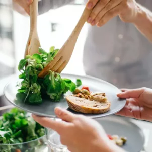 Person doling out healthy plate portions for a well-balanced meal