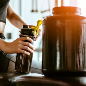 Woman making a protein shake to go to complement her workout