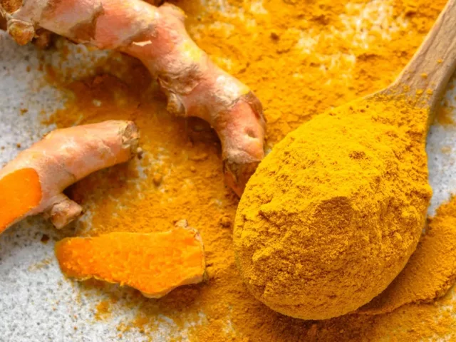 Fresh turmeric root and ground turmeric powder to illustrate its anti-inflammatory benefits