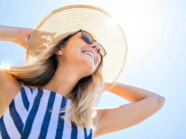 Woman wearing sunhat on sunny day to help with anti-aging