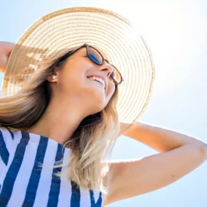 Woman wearing sunhat on sunny day to help with anti-aging