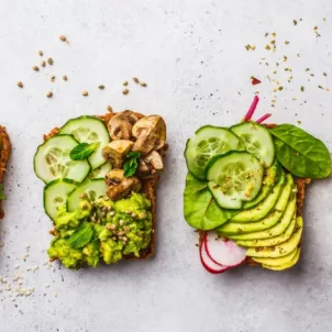 4 pieces of avocado toast with cucumbers and radishes