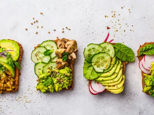 4 pieces of avocado toast with cucumbers and radishes