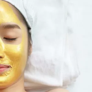 Woman at spa wearing a gold face mask