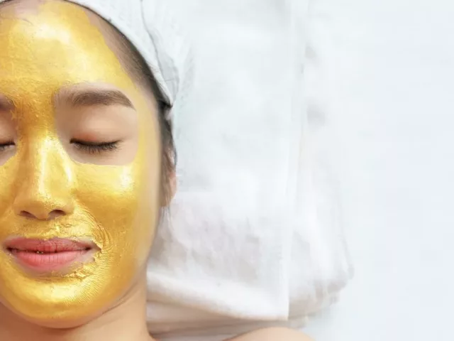 Woman at spa wearing a gold face mask