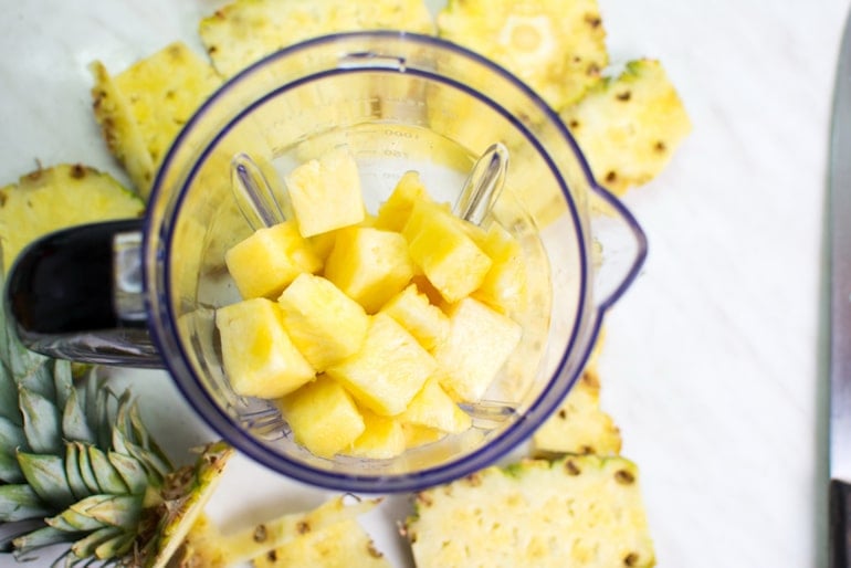 Chopped pineapple in a blender to make a DIY face mask for bromelain benefits for skin