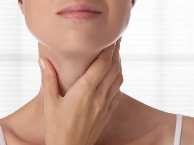 Woman checking on her thyroid glands under neck